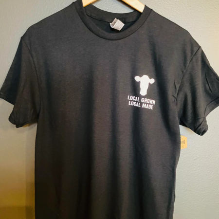 Black cotton t-shirt featuring a cow graphic and the text "Local Grown Local Made," showcasing a commitment to local agriculture and craftsmanship. Ideal for casual wear or promoting local businesses.